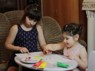 Girls playing with painting with their hands