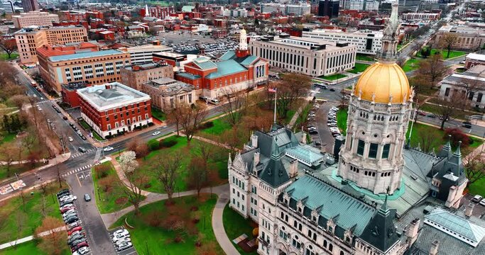 Drone approaching the stunning building of Connecticut State Capitol in the scenery of Hartford, Connecticut, the USA. Bright low-rise architecture at backdrop.