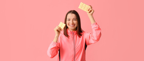 Young woman with white chocolate bars on pink background