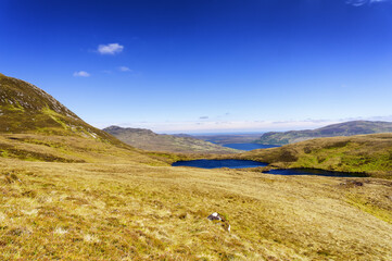 Vue des lochs et des montagnes au sommet du Ben Loyal en randonnée en Ecosse au printemps