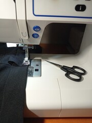 sewing machine, needle, small scissors and fabric