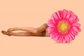Woman in nude stockings lying on beige background