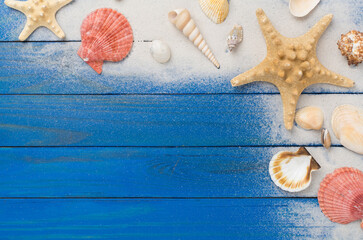 Sea shells, starfish and sand on wooden background, top view