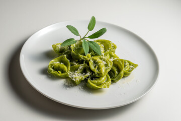 Dinner plate of green ravioli with sage and parmesan