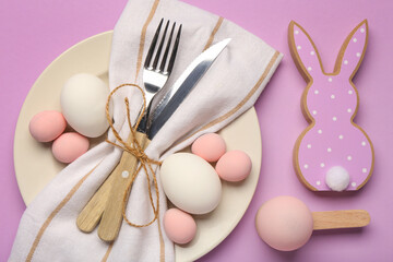 Stylish table setting with Easter eggs, napkin and cutlery on purple background