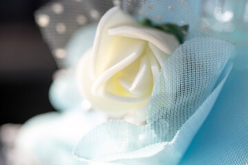 white artificial flower and blue tulle  close-up.