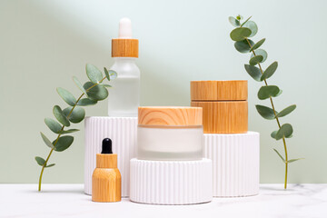 Eucalyptus cosmetics on white podiums with natural backdrop