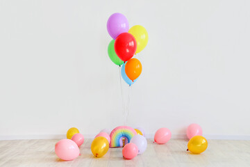 Fototapeta na wymiar Floating and lying balloons near white wall