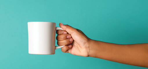 Hand Holding Blank Coffee Mug By Handle on Color Background