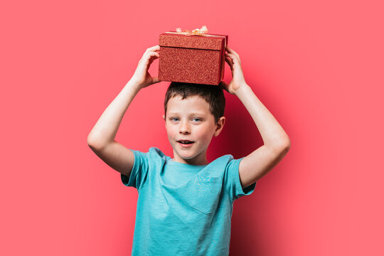 Young boy holding a gift box above his head