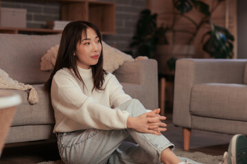 Young beautiful Asian woman relaxing at home