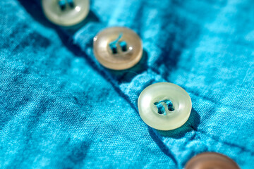 Button sewn on fabric  macro photo.