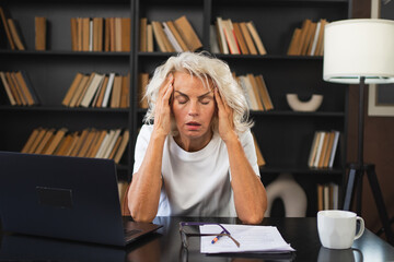Headache pain. Middle aged woman touching temples experiencing stress. Mature old lady tired of work feeling headache sick rubbing temples forehead. Long laptop usage computer vision office syndrome