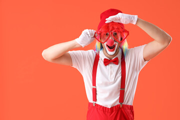 Portrait of clown with novelty glasses on orange background. April Fool's day celebration