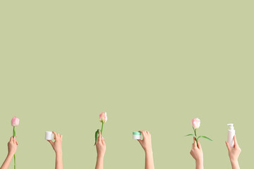 Women with cosmetic products and tulips on green background