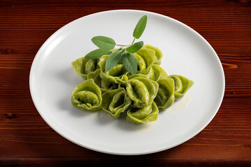 Dinner plate with green ravioli and sage