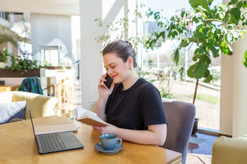 Millennial Businesswoman on Phone with Coffee and Laptop