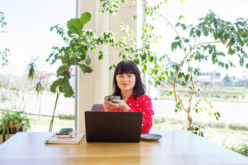 Smiling Woman with Coffee Enjoying Sunny Office View. Workspace.