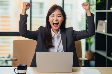 Une femme travaillant sur son ordinateur est heureuse d'avoir r&eacute;ussie son travail.
