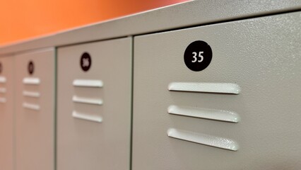 Gray lockers with numbers for people's clothes in the gym locker room. Close-up