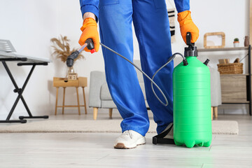 Male worker disinfecting floor in room, closeup