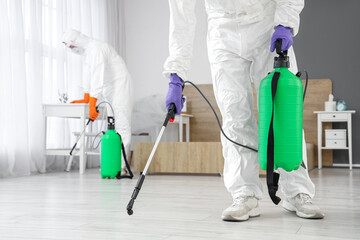 Male worker disinfecting floor in bedroom, closeup