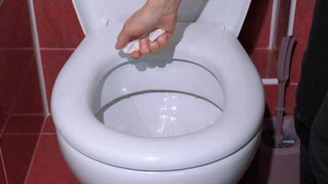 Female feel digestion problem in toilet. A woman with digestion trouble hold the soft paper by the toilet bowl indoor.