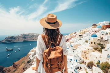 Fototapeten woman in traditional greek village Oia of Santorini, with blue domes against sea and caldera, Greece © neirfy