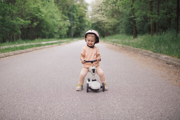 Little girl riding push scooter