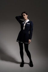 Fototapeta premium Portrait of attractive caucasian young brunette woman in school uniform in studio. Elegant woman posing. Pretty stylish model. Beauty, Style, Fashion, Luxury