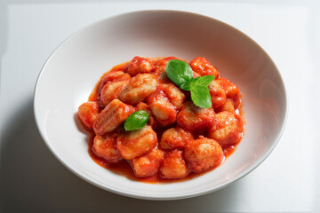 White bowl with tomato potato dumpling