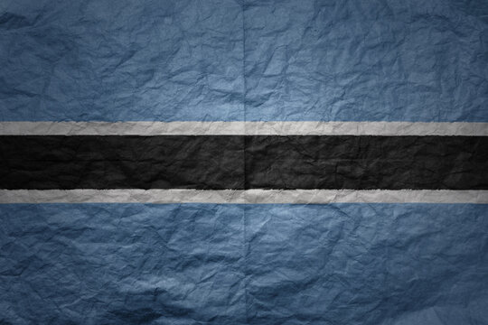 big national flag of botswana on a grunge old paper texture background