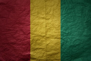 big national flag of guinea on a grunge old paper texture background