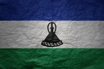 big national flag of lesotho on a grunge old paper texture background