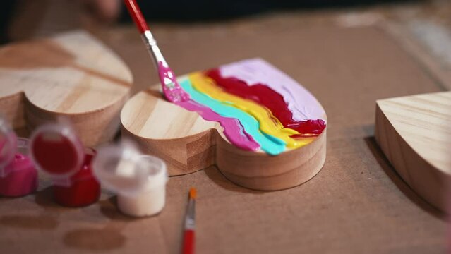 Painting a wooden heart with different colors 