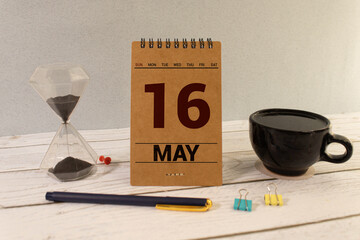 Vintage photo, May 16th. Date of 16 May on wooden cube calendar, copy space for text on board.