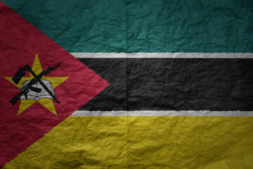 big national flag of mozambique on a grunge old paper texture background