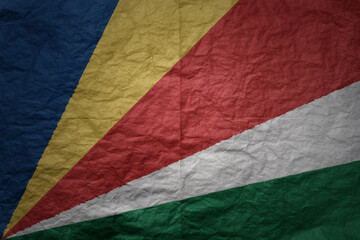 big national flag of seychelles on a grunge old paper texture background