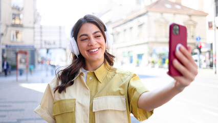 Beautiful Spanish woman taking a selfie on the street