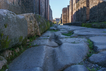 Roman street on a sunny day through the Ruins of Pompeii, Campania, Italy