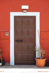 Ancient and colourful front door with flower pot - 786711442