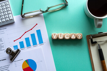 There is wood cube with the word VUCA. It is an abbreviation for Volatility, Uncertainty, Complexity, Ambiguity as eye-catching image. - obrazy, fototapety, plakaty