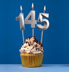 Vertical birthday card with cupcake - Lit candle number 145 on blue background