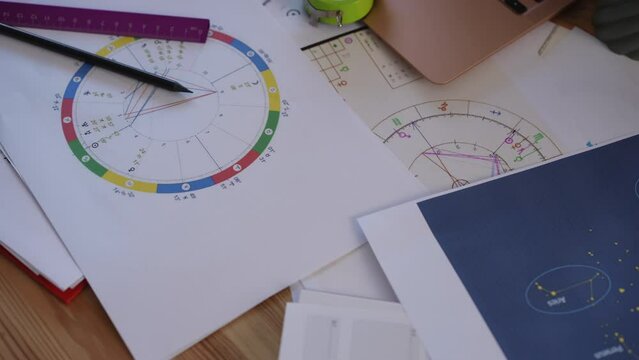 Close-up. A table with astrological accessories and a laptop in the office of a modern astrologer