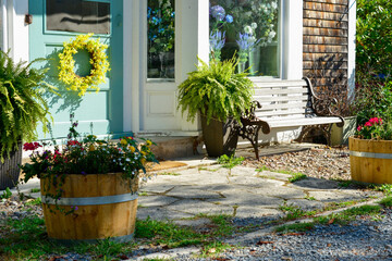 The front of a country-style floral shop. The glass windows have multiple vases of colorful...