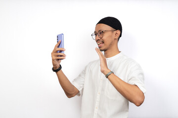 Asian Muslim men show joy when video calling with family in their hometown. The concept of celebrating Eid long distance