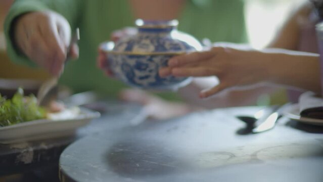 manos de mujer moviendo un plato con sopa caliente china