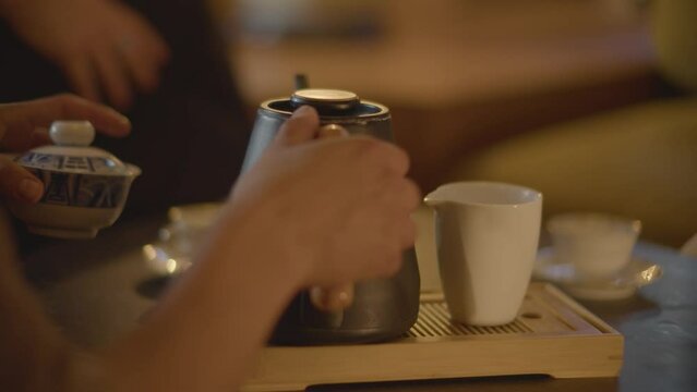 mano sirviendo una taza de t&eacute; chino