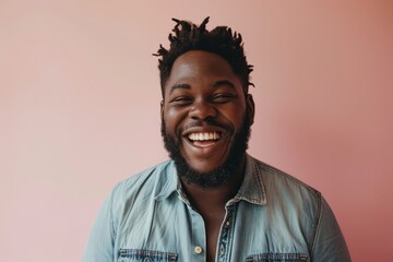 Cheerful african american man laughing on pink background.