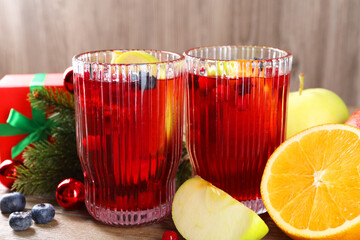 Aromatic Sangria drink in glasses, ingredients and Christmas decor on table